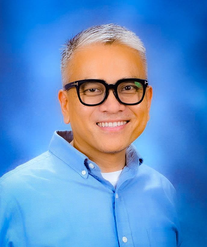 Dr. Rolly Alfonso-Maiquez wearing glasses and a blue shirt